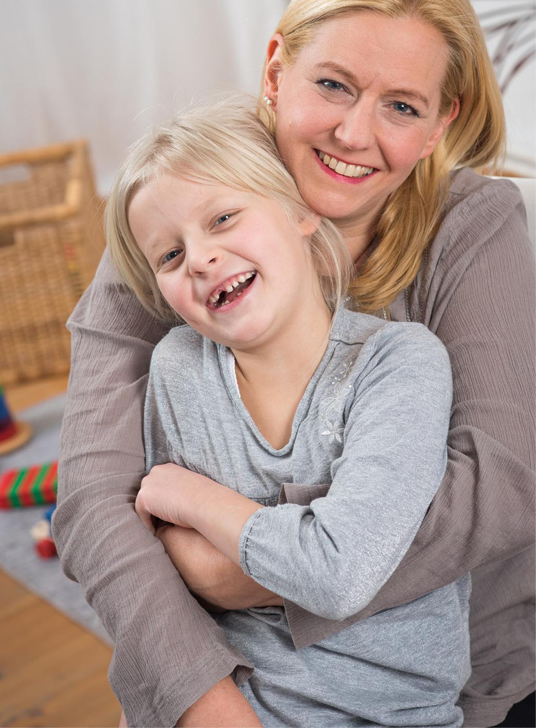 Lachende Mutter mit Tochter im Arm 